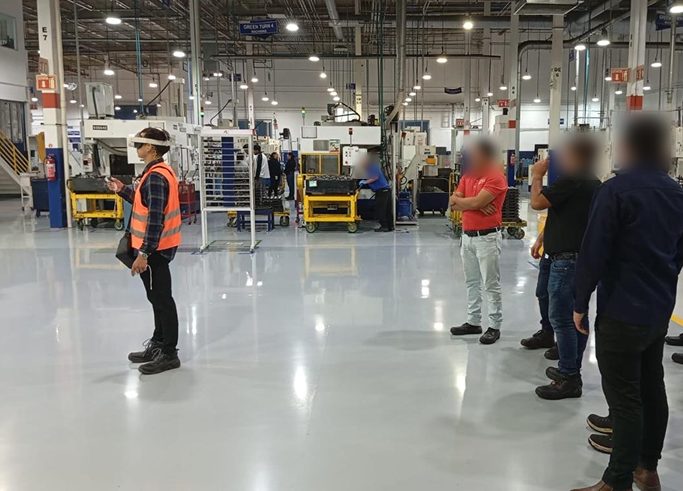 Froylan Díaz usa un visor Meta Quest 3 en la planta de AAM mientras supervisores observan la demostración