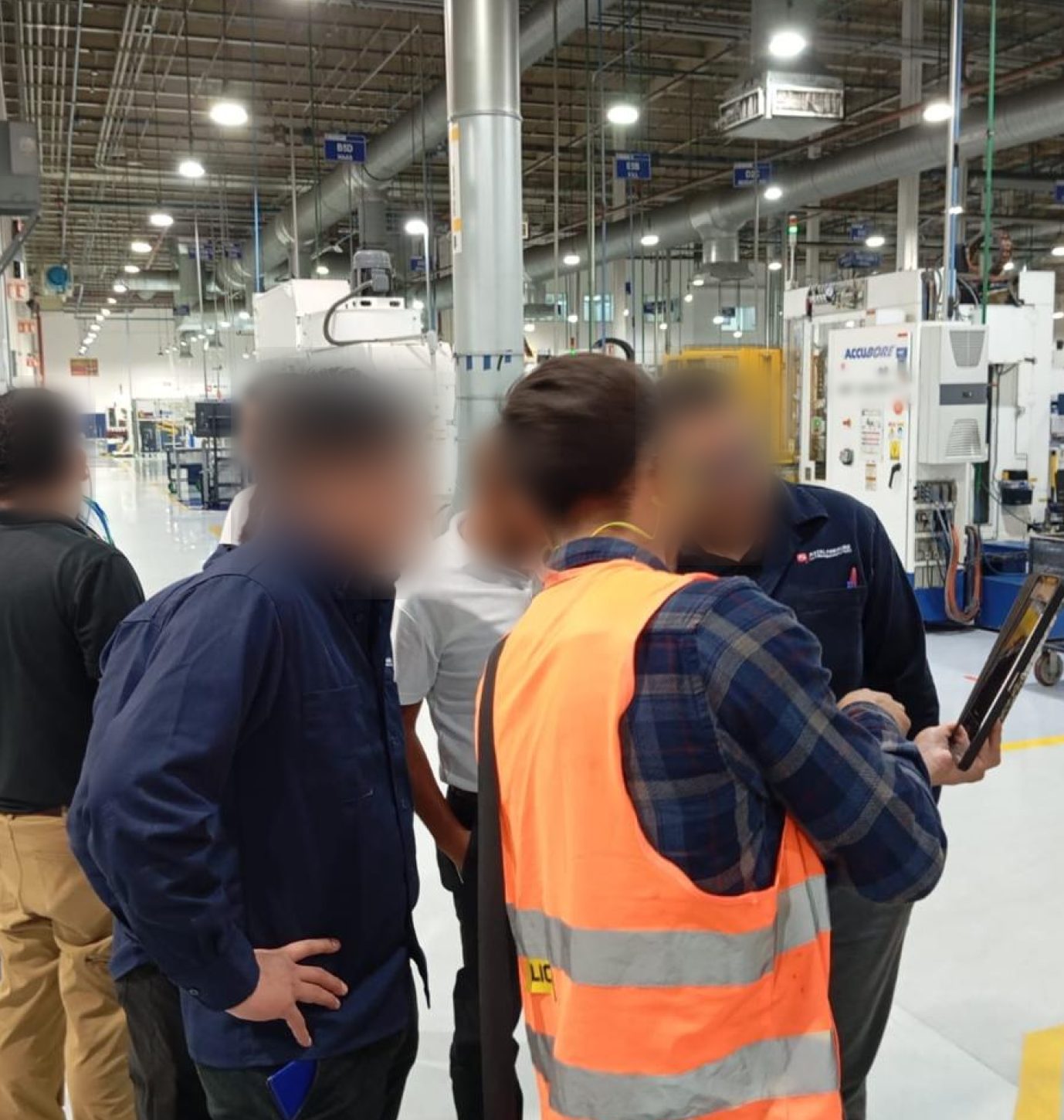 Froylan Díaz muestra la app AR en una tablet a operadores de AAM durante una sesión de pruebas en planta